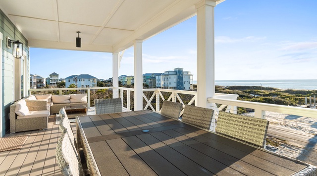 Unwind in your spacious covered porch with ocean breezes and coastal views—perfectly furnished for morning coffee or sunset cocktails with loved ones.