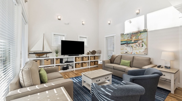 Unwind in your bright, coastal-inspired living room with soaring ceilings, comfortable seating, and nautical touches that create the perfect beachside retreat atmosphere.