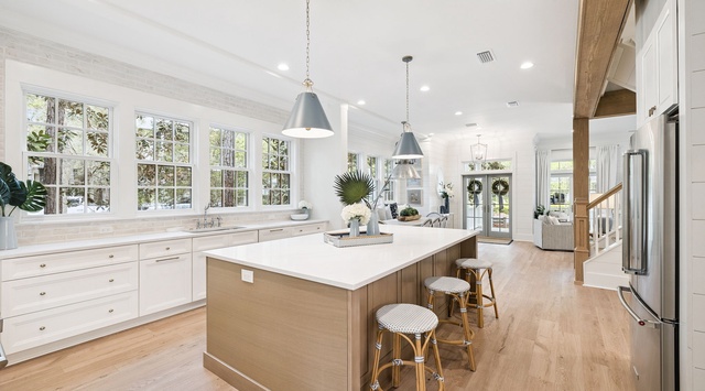 Your gourmet kitchen awaits with marble countertops, spacious island seating, and sunlight streaming through garden-view windows.