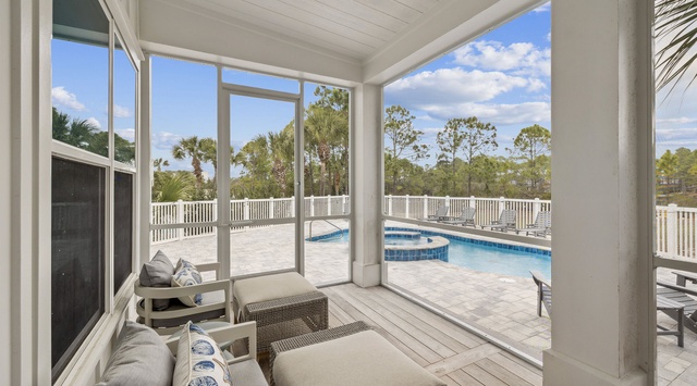 Relax in your screened porch with pool views, where comfortable seating and tropical breezes create the perfect retreat.