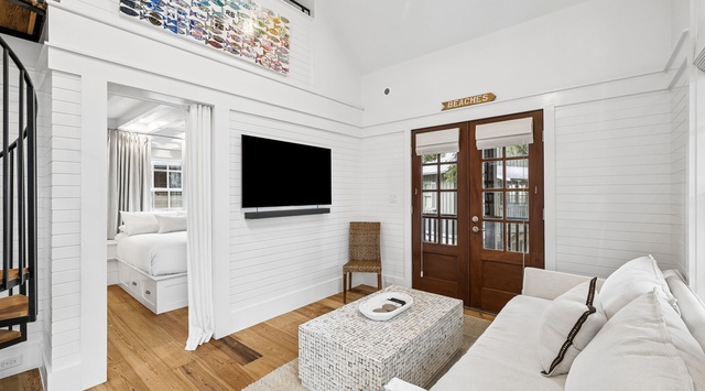 Unwind in your bright, coastal-chic living space with soaring ceilings, warm wood floors, and beach-themed art. Curl up on plush seating, catch up on your favorite shows, or step through French doors to explore outside.