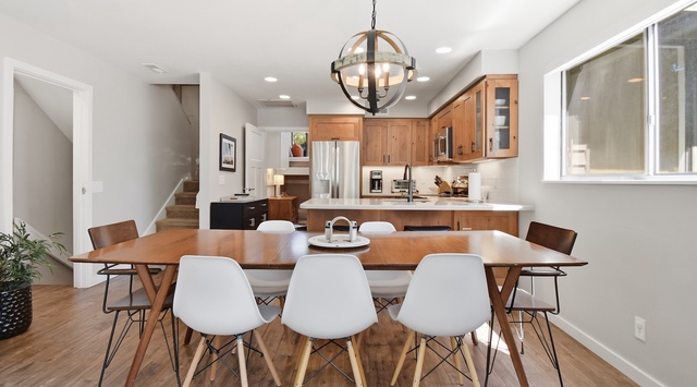 Gather around this inviting dining table where warm wood tones and modern design create the perfect setting for your meals together, with a fully equipped kitchen ready for your culinary adventures.