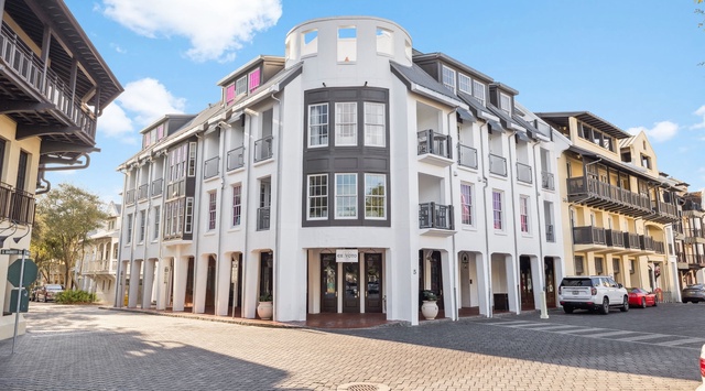 Modern luxury building anchors a charming cobblestone square, surrounded by historic architecture and convenient street-level shopping.