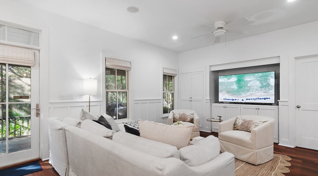 Sink into plush white sofas in your elegant living room, where natural light streams through French doors and you can unwind watching your favorite shows.