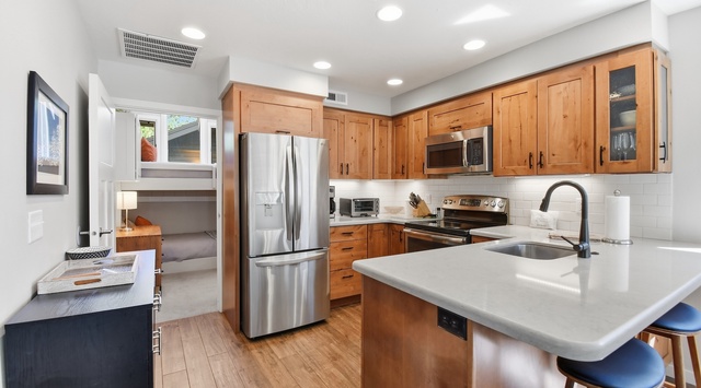 Your fully equipped kitchen features warm wood cabinetry, gleaming countertops, and modern stainless appliances—perfect for whipping up meals while enjoying the bright, airy space.