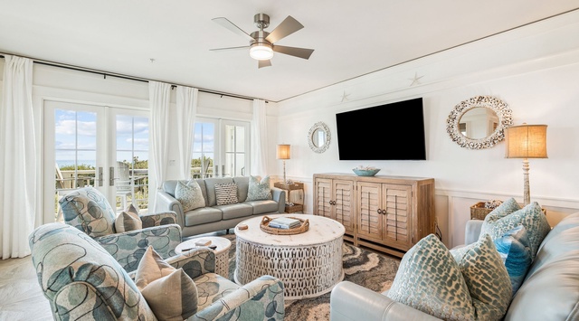 Step into your coastal retreat where soft blues meet natural textures. Sink into plush seating, enjoy your favorite shows on the large TV, and feel the ocean breeze through open French doors.