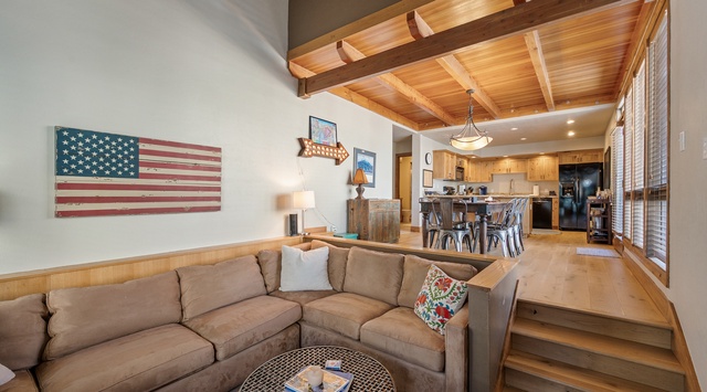 Sink into this plush sectional and admire the rustic wood beams overhead while your open kitchen awaits your culinary adventures.