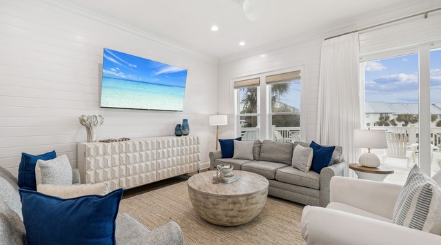 Unwind in your bright living space with coastal views through floor-to-ceiling windows and comfortable seating perfect for relaxing.