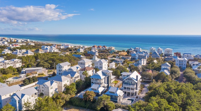 Stunning coastal community with beach houses nestled among lush trees, offering easy beach access and serene ocean views.