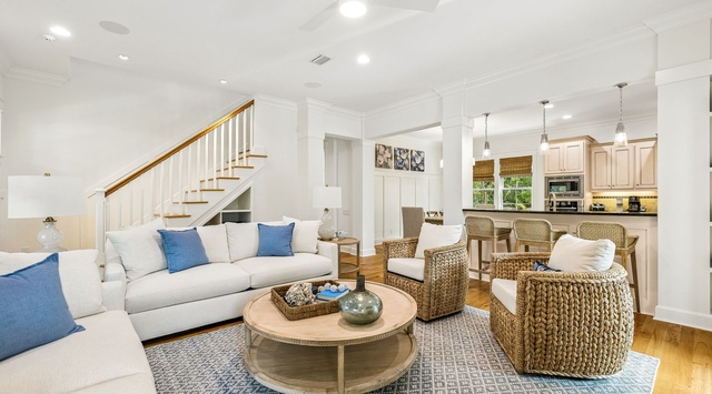 Sink into plush sofas and textured wicker chairs in your open-concept living space, where natural light streams through the kitchen and coastal-chic décor invites your perfect getaway.