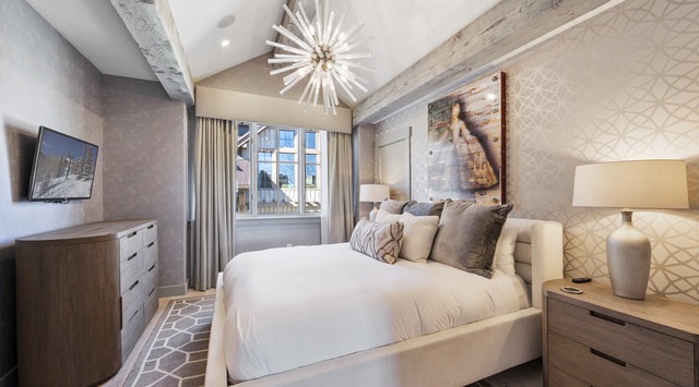 Sink into luxurious comfort in this elegantly appointed bedroom, where rustic beams meet modern sophistication for your perfect mountain retreat.