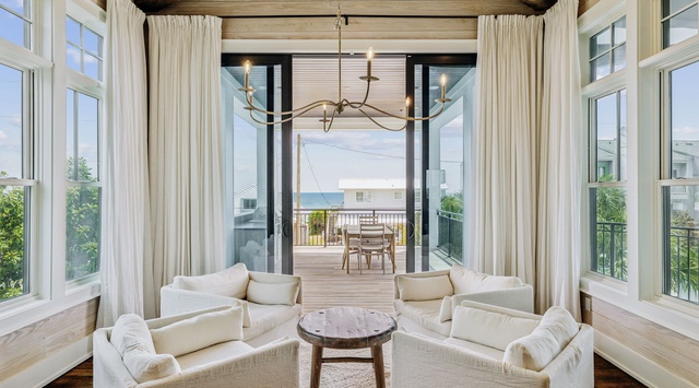 Sink into plush white seating beneath soaring beams while ocean breezes flow through your private terrace doors.