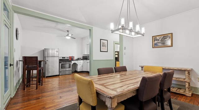 Gather around your rustic dining table where warm hardwood floors and elegant lighting create the perfect setting for memorable meals together.