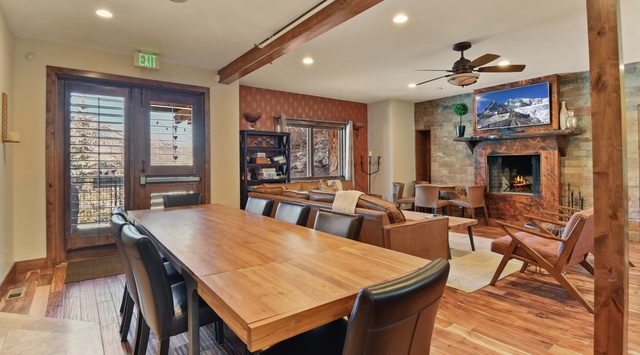 Gather around your beautiful wood dining table while the stone fireplace crackles nearby, creating perfect moments for memorable meals together.