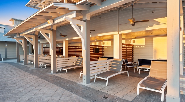 Stretch out on a lounge chair under the shade of a beautifully designed pergola, where ceiling fans keep the breeze flowing and privacy screens frame your quiet moment. Perfect for soaking up the sun or unwinding with friends.