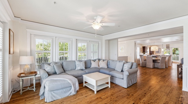 Unwind on the plush sectional sofa as natural light streams through tall windows, creating a perfect spot for your morning coffee.