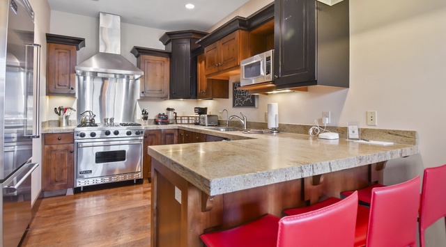Your gourmet kitchen awaits with granite counters, professional-grade stainless appliances, and a breakfast bar perfect for morning coffee conversations.