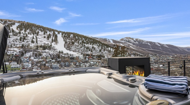 Unwind in your private hot tub while soaking in breathtaking mountain views and warming by the sleek outdoor fireplace.