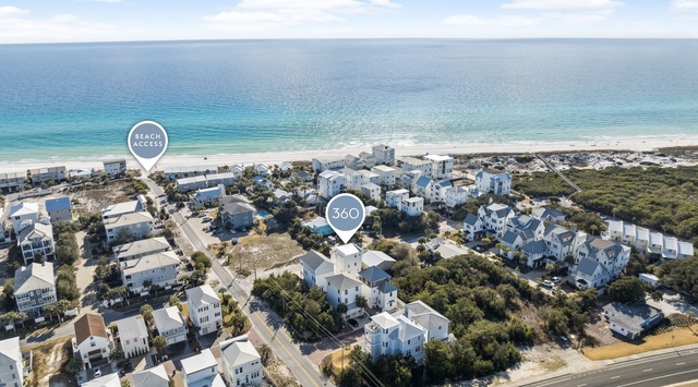 Aerial view of a coastal community with pristine beaches and turquoise waters nearby.