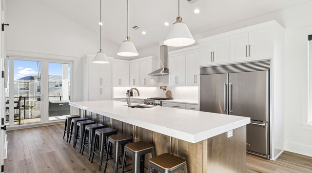 Gather around this stunning modern kitchen where gleaming white countertops invite you to cook and connect with loved ones over breakfast.