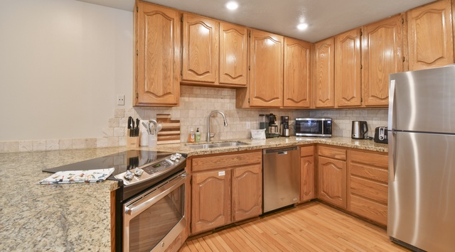 Your fully equipped kitchen features granite counters, stainless appliances, and warm wood cabinets—everything you need to create memorable meals together.