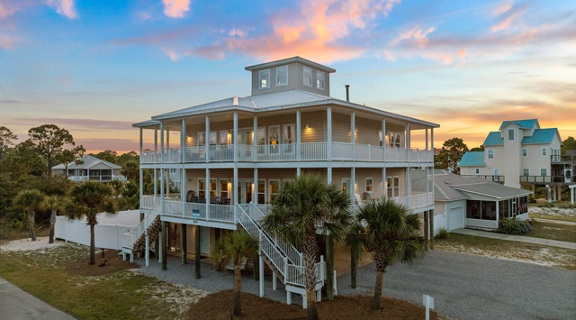 A stunning coastal retreat rises three stories high, surrounded by swaying palms and just steps from the beach. Wide wrap-around porches and an observation tower frame breathtaking sunset views over the surrounding area.