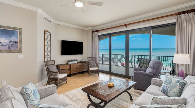 Relax in your spacious living room where soft furnishings and a gentle ceiling fan breeze meet stunning emerald gulf views through floor-to-ceiling doors opening to your private balcony.