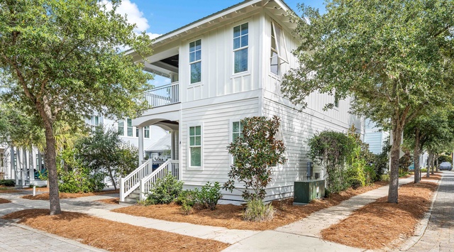 Charming coastal-style home nestled among mature trees on a quiet residential street, offering peaceful surroundings for your getaway.