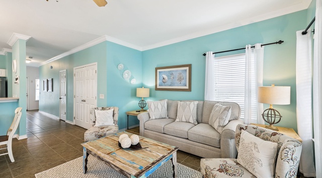 Unwind in your coastal-themed living room with soft turquoise walls, comfortable seating, and nautical décor creating the perfect beach house atmosphere.