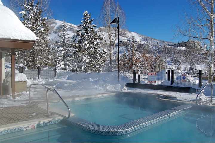 A heated outdoor hot tub offers scenic mountain and ski slope views, inviting you to relax in warm waters after a day on the slopes.