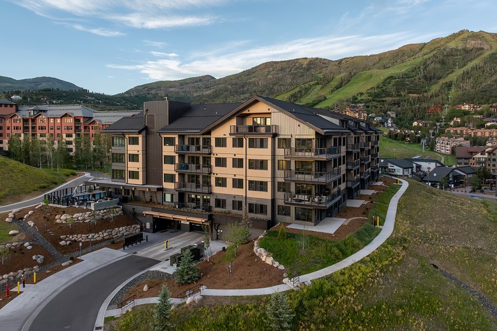 A welcoming mountain resort in a scenic valley setting, surrounded by rolling hills and neighboring properties at the base of the mountains.