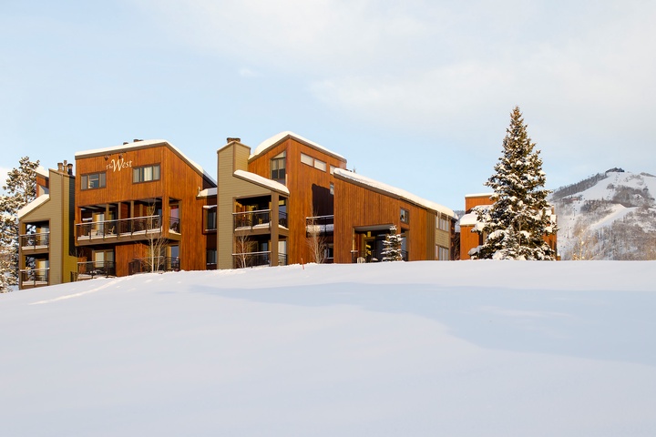 Mountain lodge property with warm wood architecture nestled in pristine snow, offering ski-in access and stunning alpine views. A classic winter retreat in a premier ski destination.
