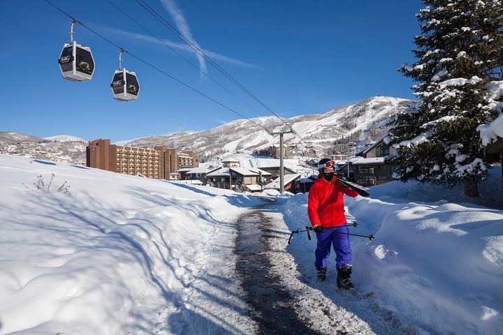 A winter ski resort nestled in snow-covered mountains, featuring gondola lifts, lodging buildings, and surrounding natural landscape. The area offers easy access to slopes and alpine scenery.