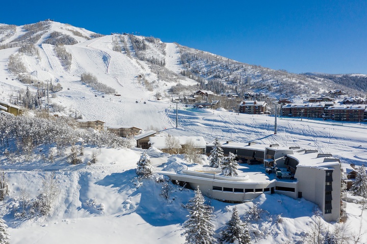 This mountain retreat sits at the base of pristine ski slopes, surrounded by snow-covered peaks and evergreens—a winter wonderland setting in the heart of resort country.