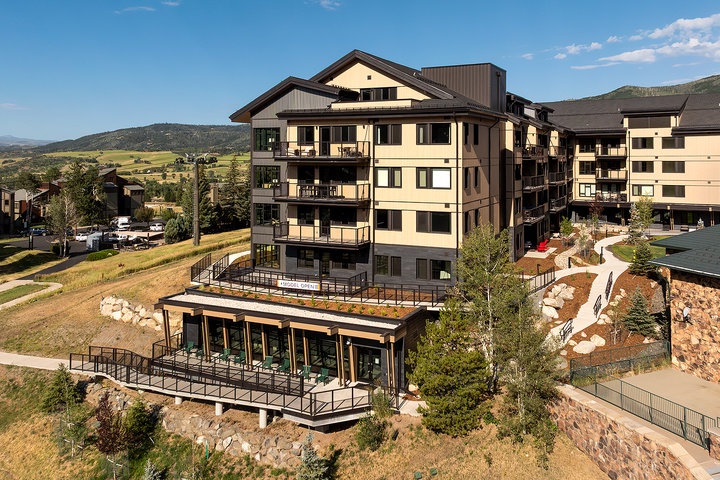 A modern multi-level property nestled in a scenic mountain valley, surrounded by rolling hills and natural landscape, offering an ideal base for exploring the area.