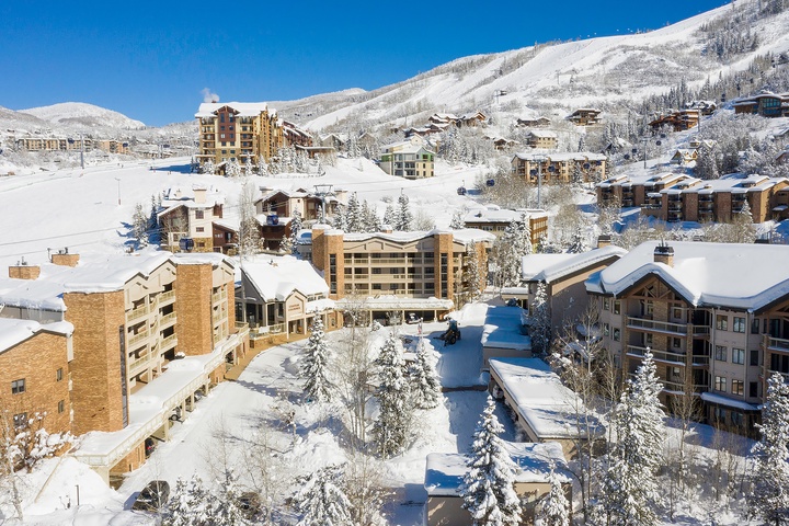 A picturesque winter resort village nestled in a snowy mountain valley, offering immediate ski slope access and alpine charm during the winter season.