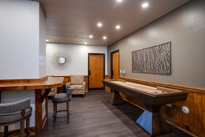 Your private game room awaits, featuring a full-sized shuffleboard table for friendly competition and a cozy seating nook—perfect for unwinding after a day of adventure.
