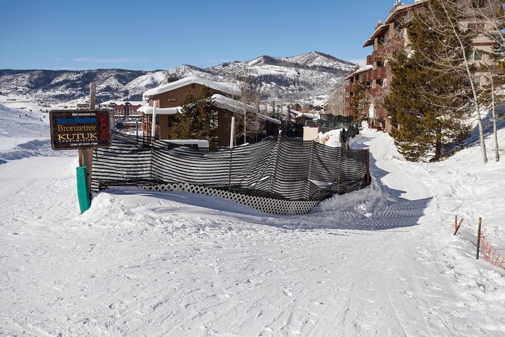 Ski resort entrance at the base of snow-covered mountains, with direct ski-in/ski-out access to the property and surrounding alpine village.