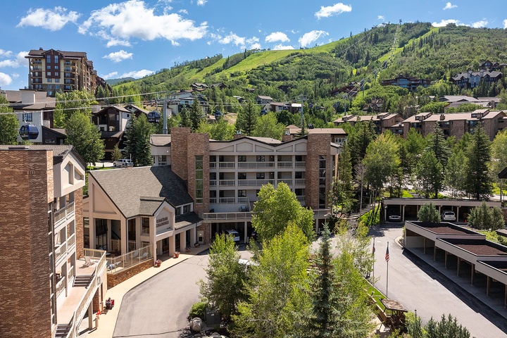 This mountain resort property sits nestled among lush green slopes, offering guests easy access to nearby outdoor activities and scenic alpine surroundings during the vibrant summer season.