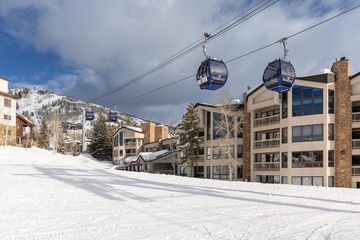 A ski-in/ski-out winter retreat nestled at the base of snow-covered slopes, with direct gondola access and modern mountain-view condos just steps away.
