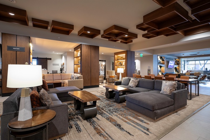 Sink into modern comfort in this stylish lobby lounge, where warm wood tones and plush seating create your perfect spot to unwind and connect.