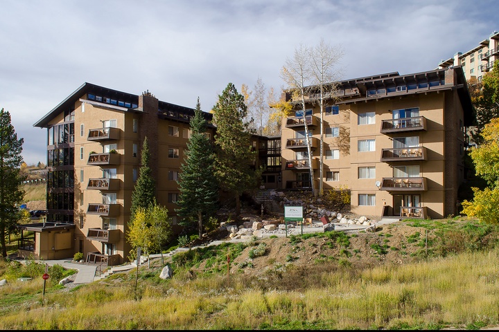 Multi-story mountainside property featuring private balconies and nestled among evergreens and aspens, offering direct access to the surrounding natural landscape.