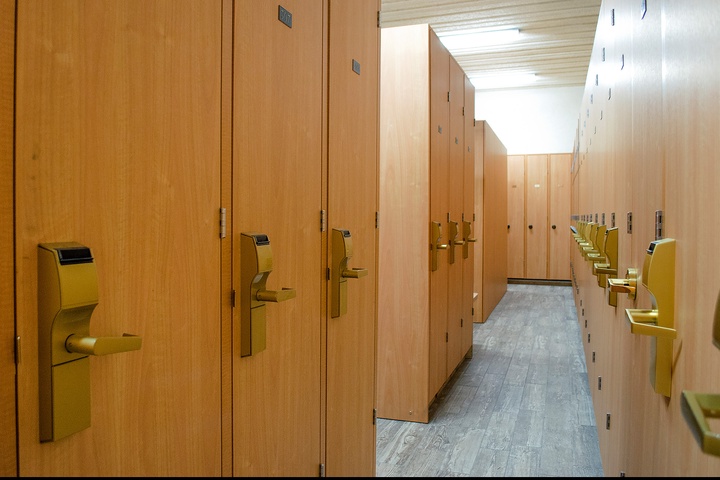 A well-organized locker room with secure storage awaits, featuring modern wood-toned lockers with electronic keyless entry systems for your convenience and peace of mind.
