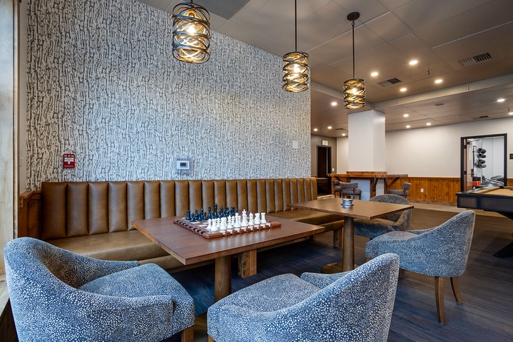 Unwind in this stylish communal lounge, featuring a chess set ready for your next match, cozy seating, and modern lighting that creates the perfect ambiance for relaxing evenings.