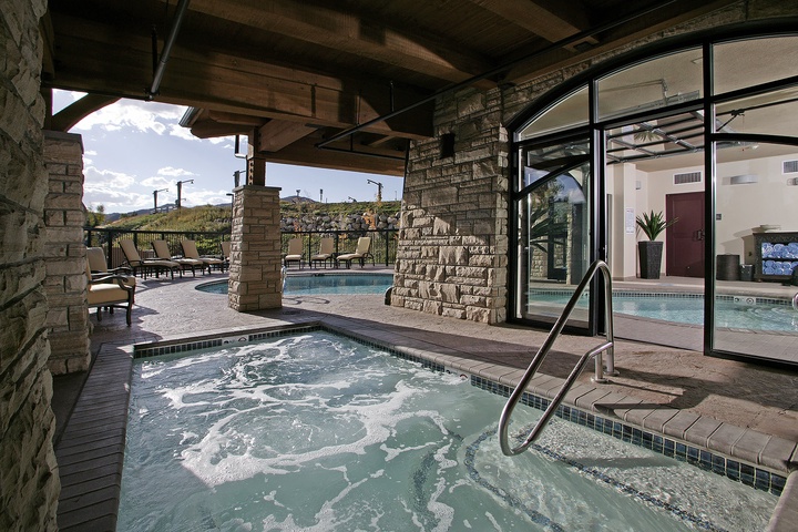 Unwind in bubbling hot tubs surrounded by warm stone accents and mountain views, with easy access to indoor and outdoor relaxation spaces.