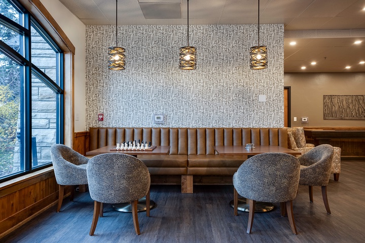 Gather around this stylish communal lounge featuring plush seating, modern lighting, and warm wood accents perfect for your relaxation or socializing during your stay.