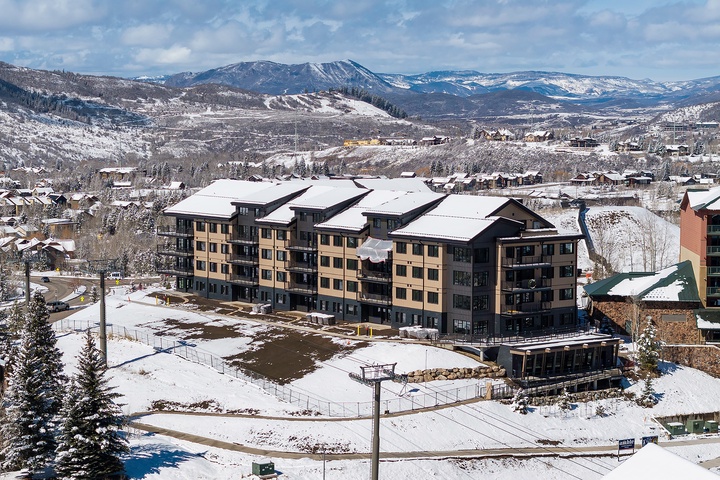 A winter retreat nestled in a snowy mountain valley, where majestic peaks frame your home away from home and crisp alpine air invites adventure just beyond the door.