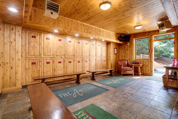 Warm wood-paneled entry greets you with organized locker storage and a cozy reading nook, blending rustic charm with practical amenities for your stay.