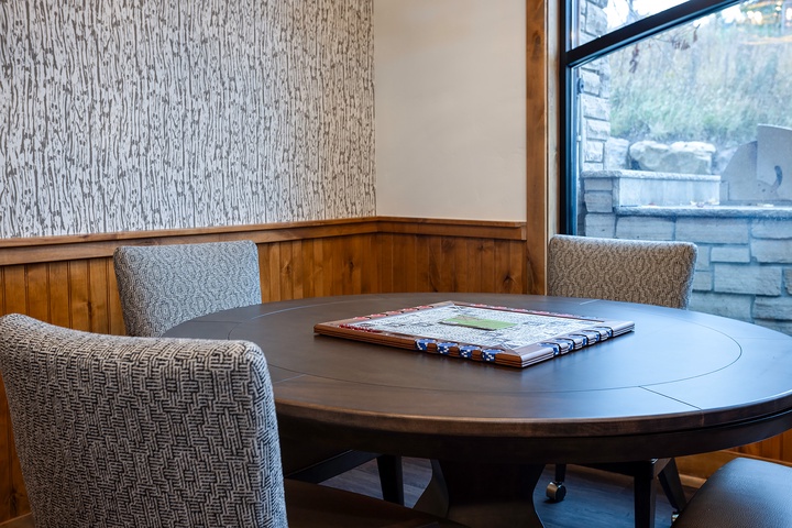 A quiet corner awaits your morning coffee or evening plans. Settle into the woven chairs at this round table, maps ready to guide your next adventure in the area.