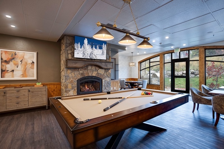 Challenge your travel companions to a friendly game in this inviting space, complete with a cozy fireplace and scenic views of the lush grounds beyond the expansive windows.